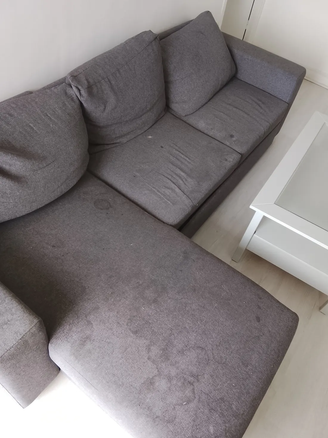Canapé d'angle en tissu gris couvert de taches